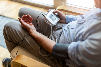 man with blood pressure monitor